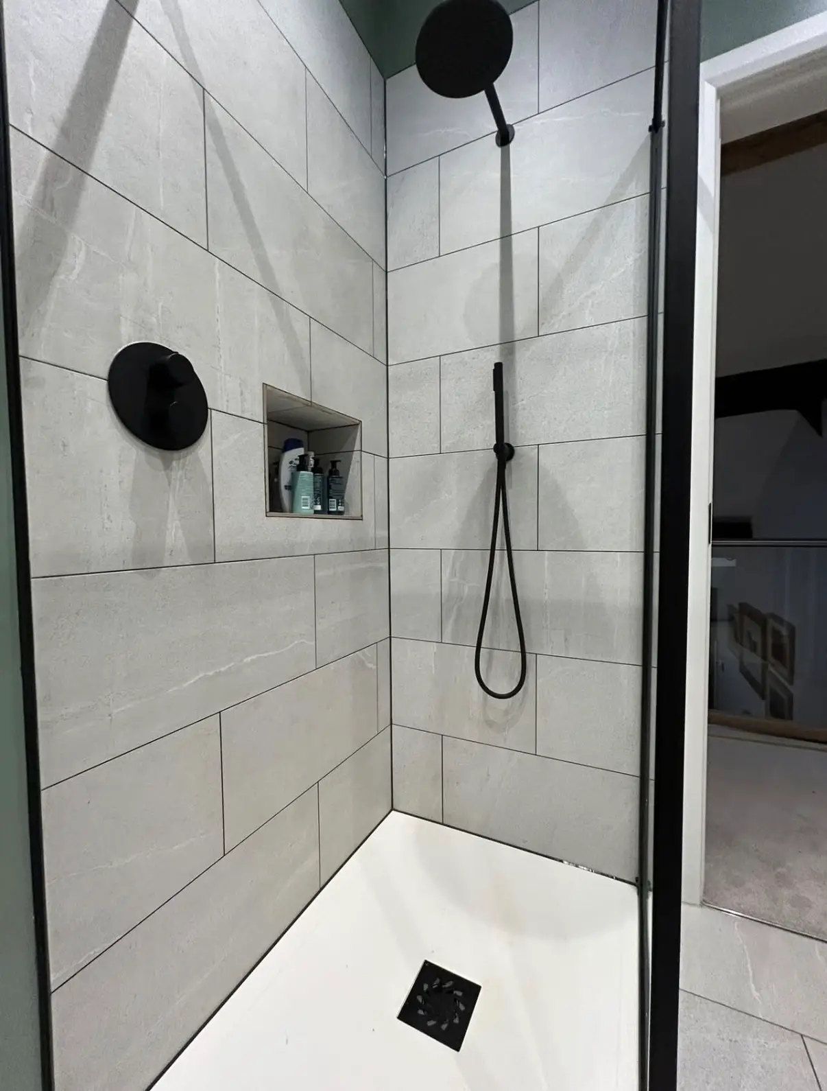 Walk-in shower with tiled walls and a clean tray edge